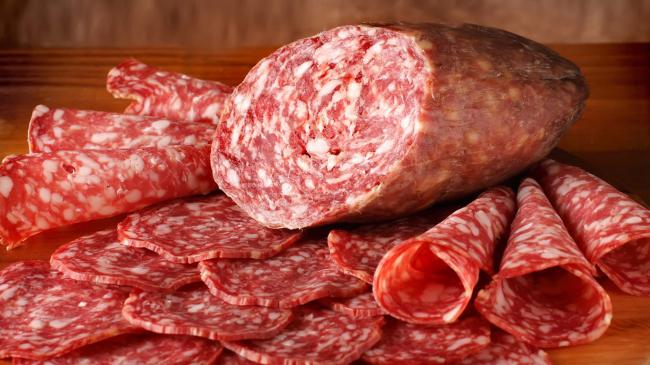 нарезанная кусочками колбаса копченая