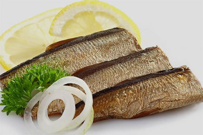 несколько целых консервированных шпрот и лимон