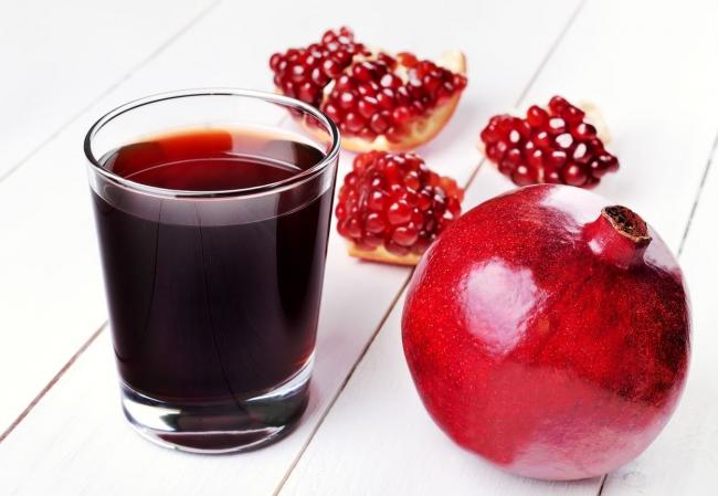 целый гранат и сок в стакане