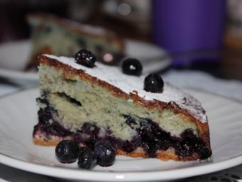 кусок шарлотки с черникой на тарелке